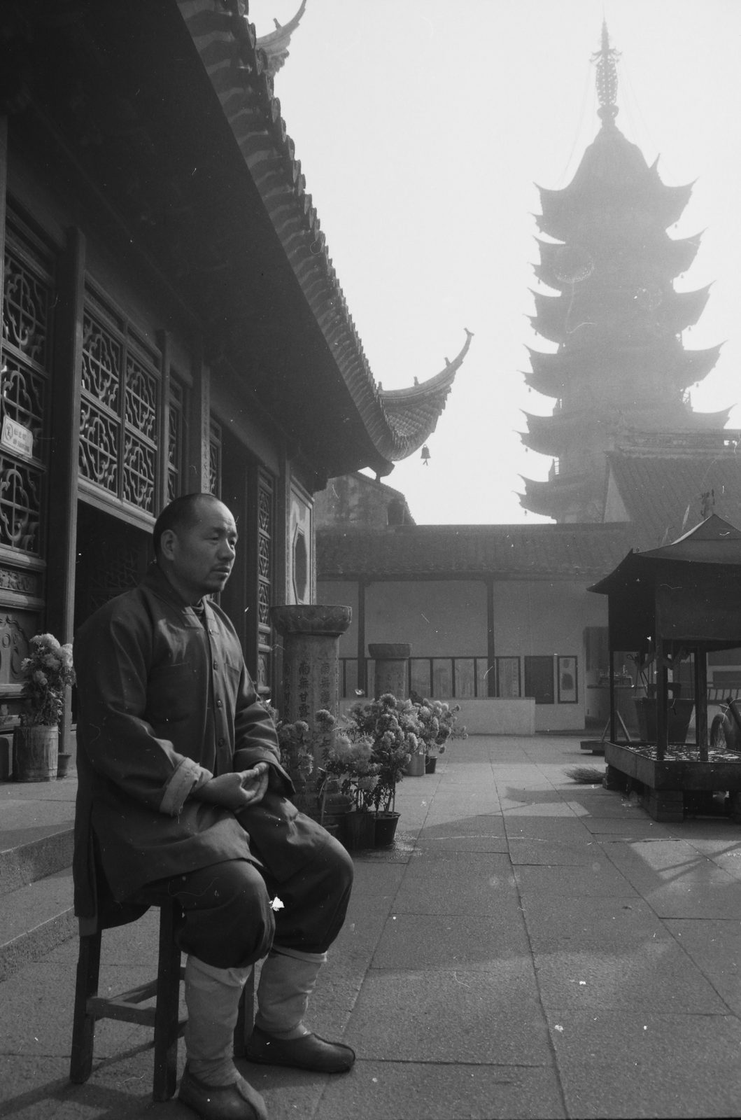黑白照片：苏州灵岩山寺，僧人坐在廊下，背景是宝塔